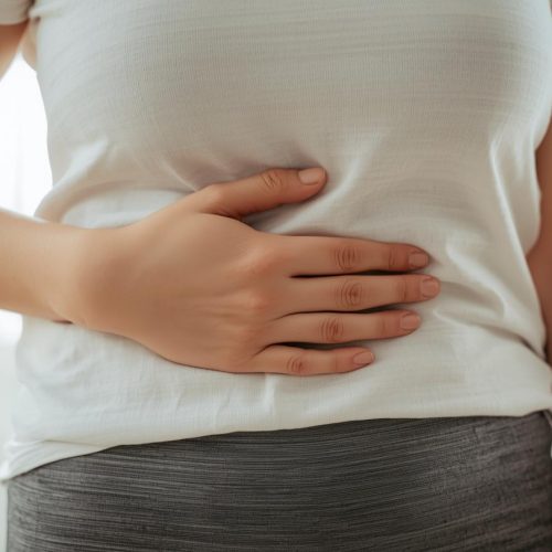 Pessoa com mão sobre o abdômen, sensação de conforto digestivo e equilíbrio